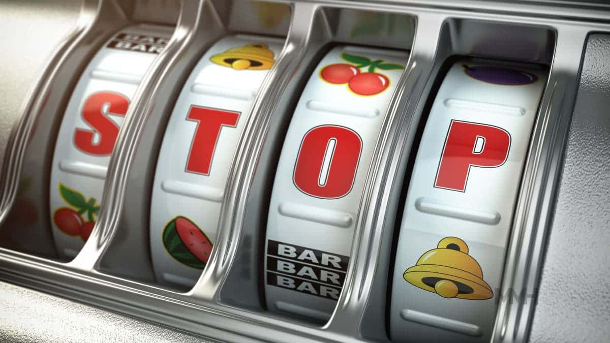 Close-up view of a slot machine displaying the word “STOP,” symbolising the need to recognise and address the compulsive nature of gambling.
