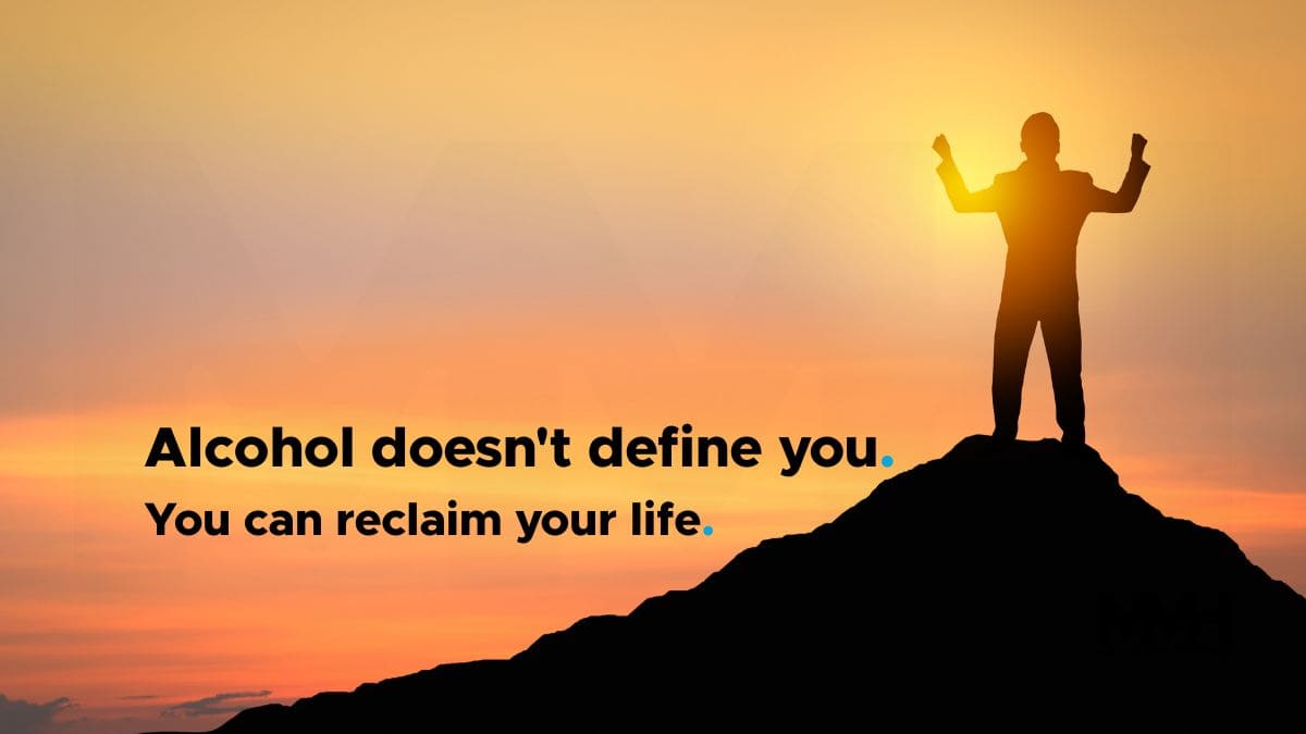 A silhouette of a man raising his arms triumphantly on a mountain at sunrise, with the words "Alcohol doesn't define you. You can reclaim your life.