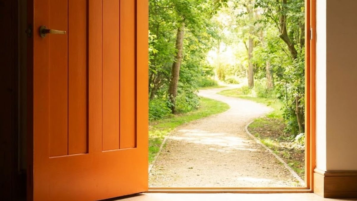An open door leading to a bright outdoor path, symbolising the start of a therapy journey.