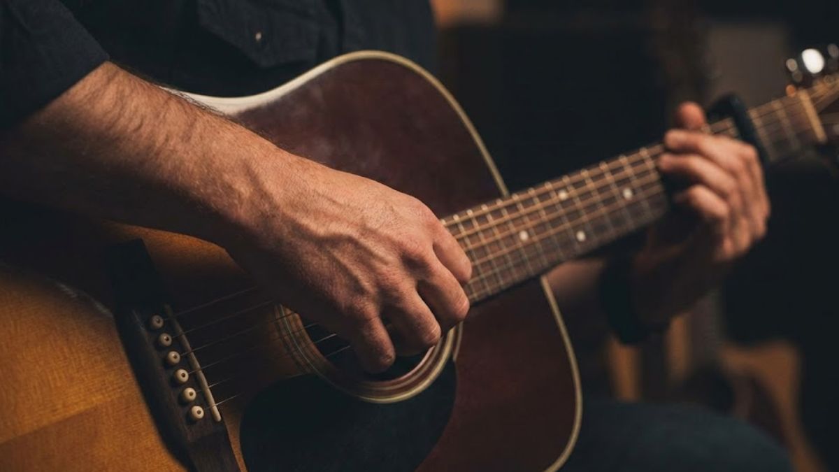 A man playing guitar as a form of non-verbal emotional release.