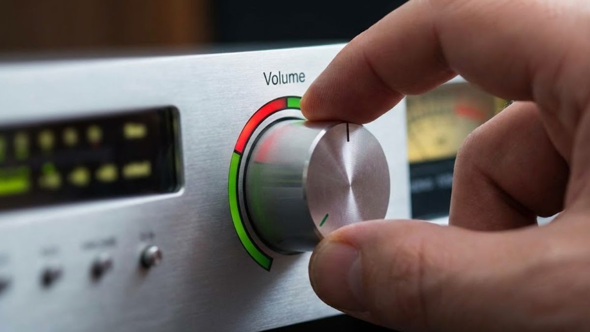 A hand turning down the volume knob on a mixing desk, symbolizing reducing anxiety levels.