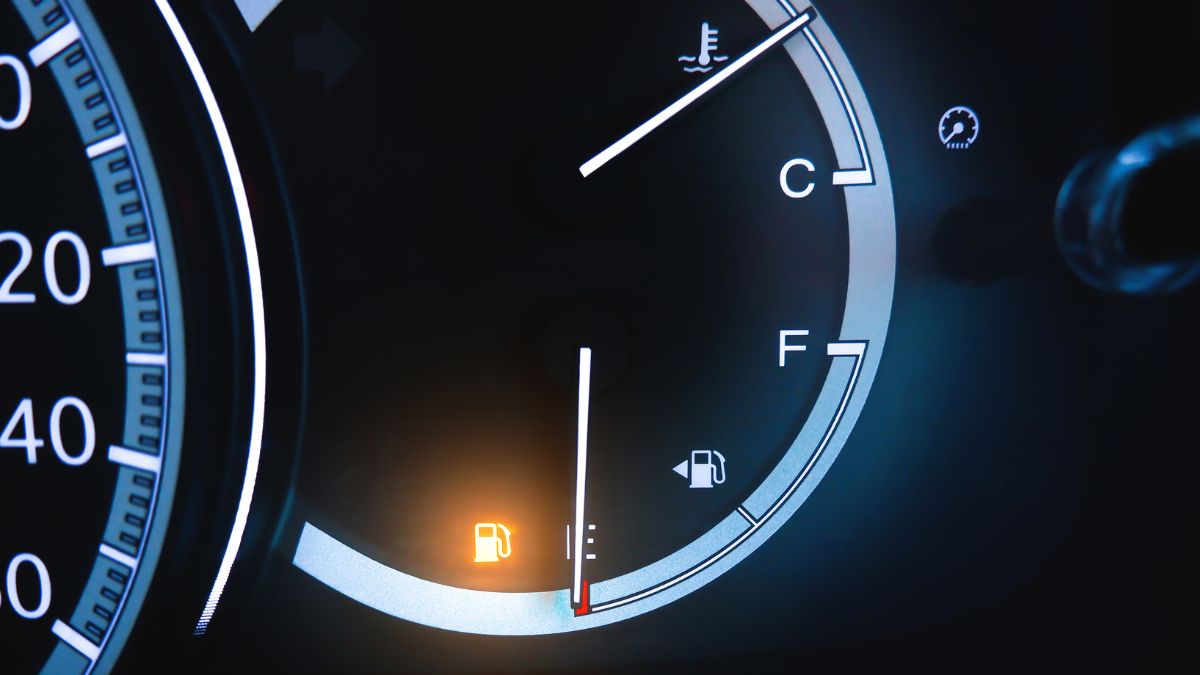 A car dashboard with a low fuel light on, metaphors for physical signs of sleep deprivation.