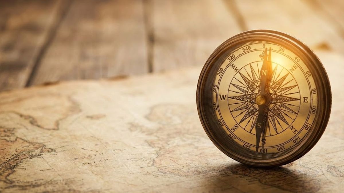 A close-up photograph of an antique compass resting on an old, worn map, symbolising the journey of understanding and finding one's way.