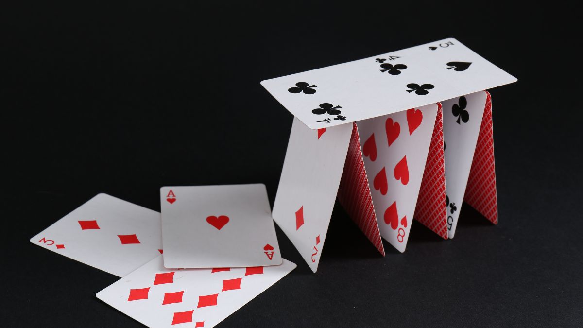A house of cards representing a fragile and constructed reality.