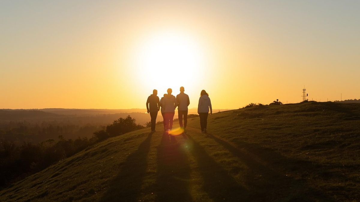 A group of people walking together at sunrise, symbolizing the hope of rebuilding social connections.