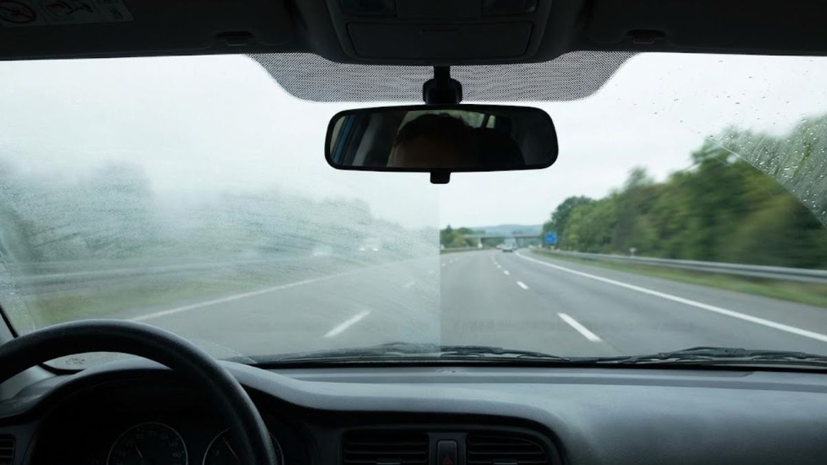 A windshield being cleared of fog representing clarity.