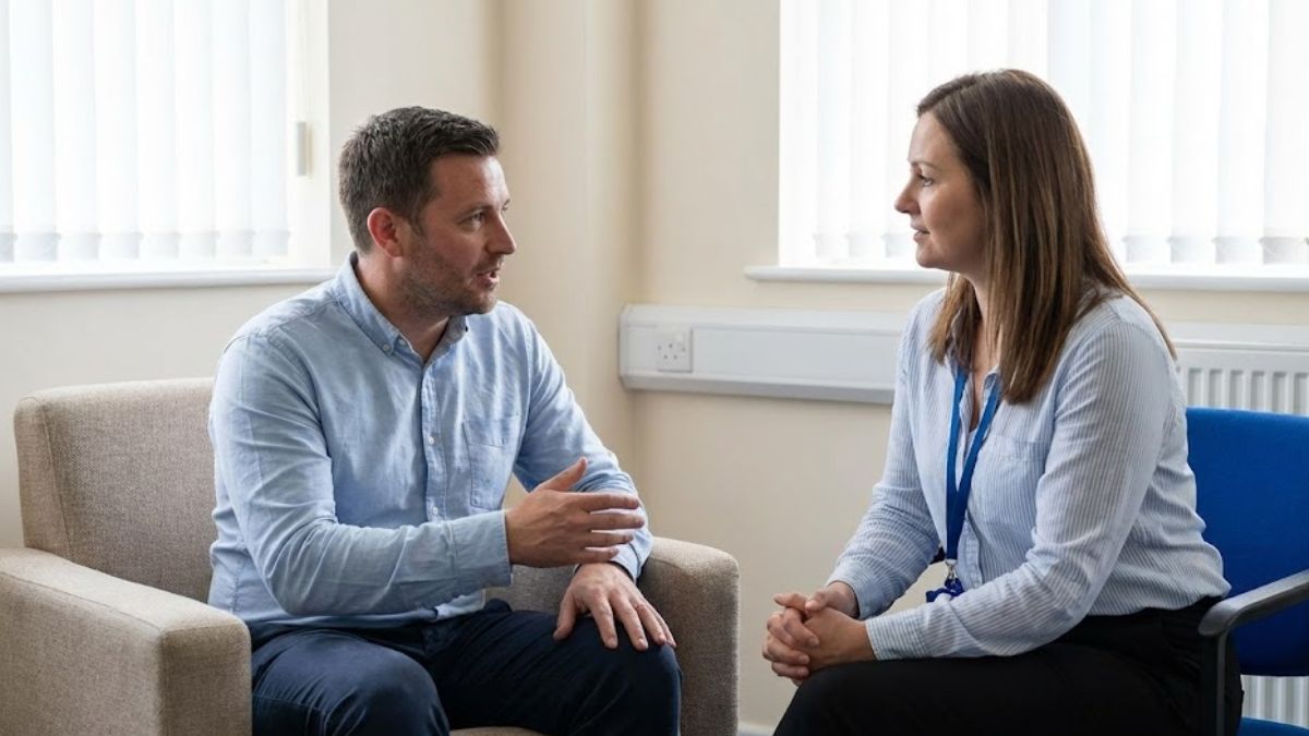 A man sitting in a calm office environment speaking with a female support worker or police liaison officer.