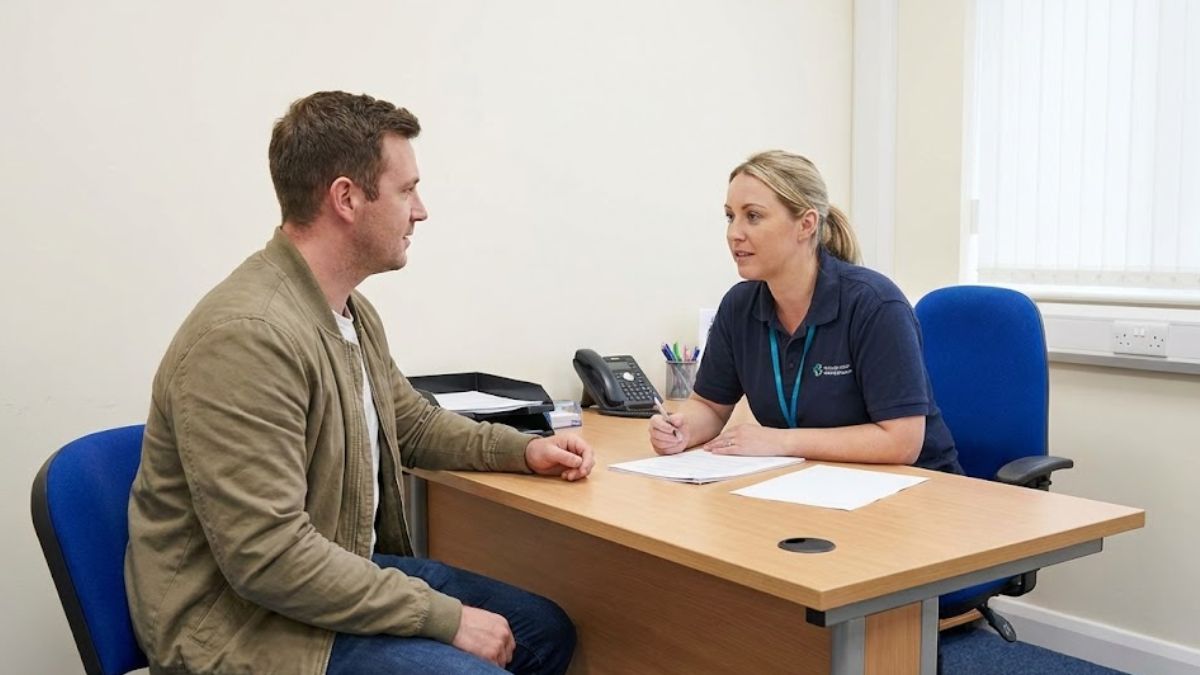 A man in a meeting with a support worker in an office, discussing his situation, illustrating the importance of seeking help.
