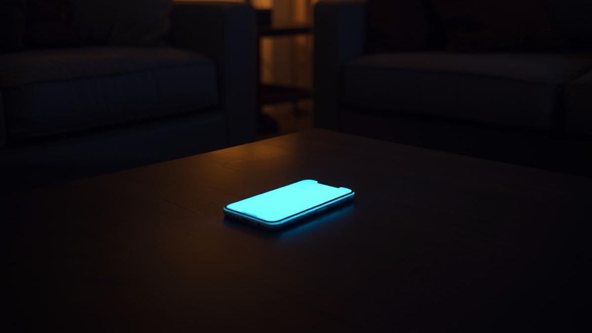 A smartphone glowing in a dark room, illustrating revenge bedtime procrastination.