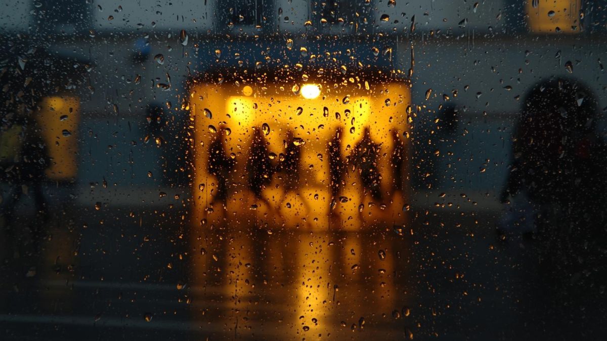 Looking through a rainy window at a busy street, representing the isolation of depression.