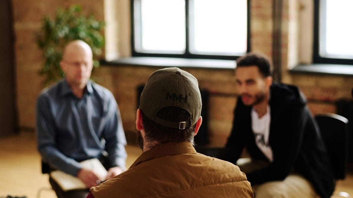 blokes i a room talking and listening