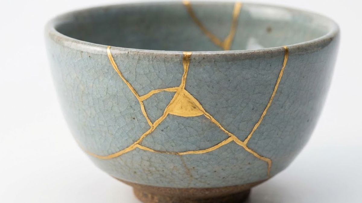 A close-up of a ceramic bowl repaired with gold lacquer (Kintsugi), symbolizing healing and the beauty of resilience.